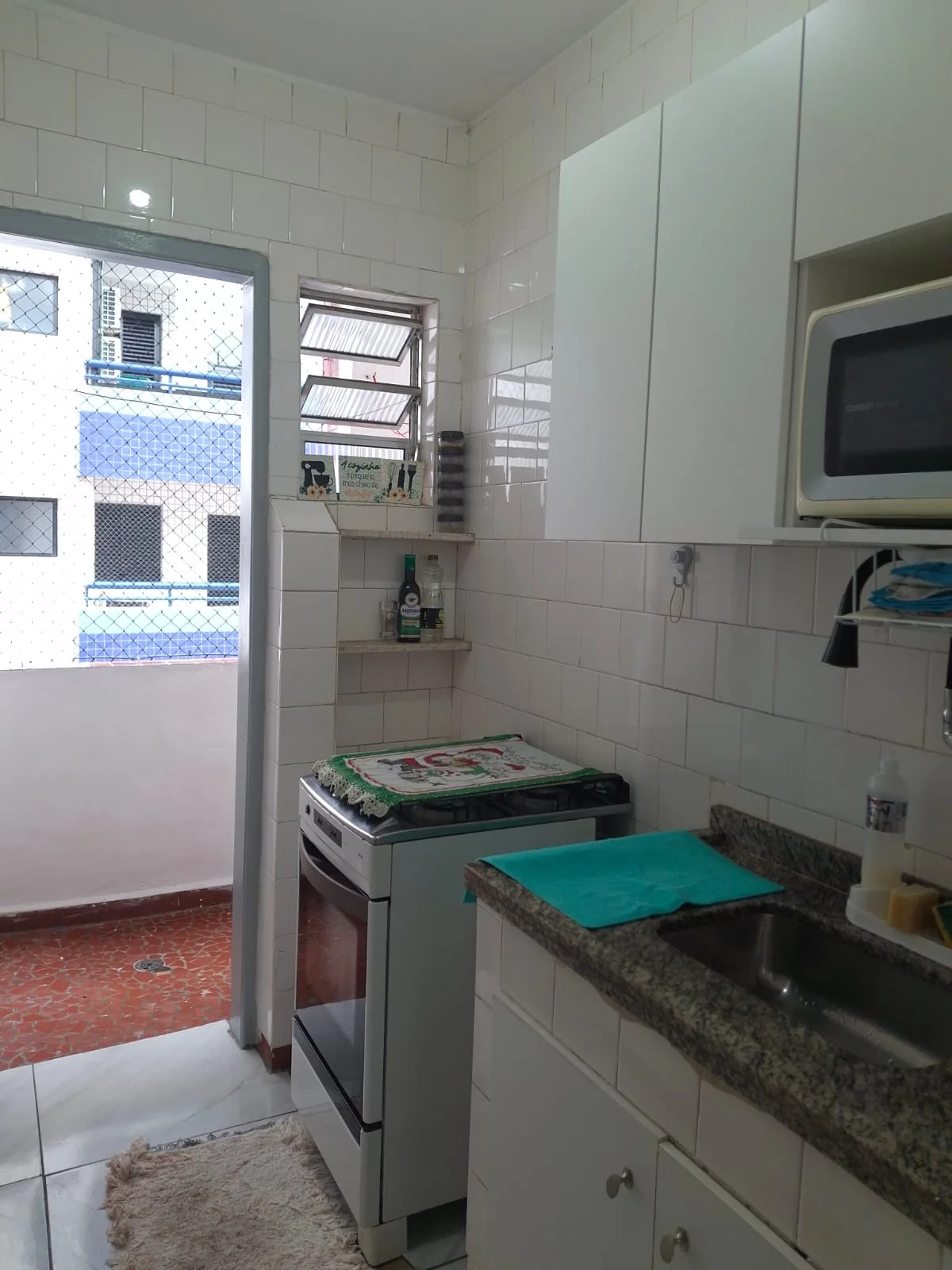 Cozinha com fogão, armários e bancada de granito