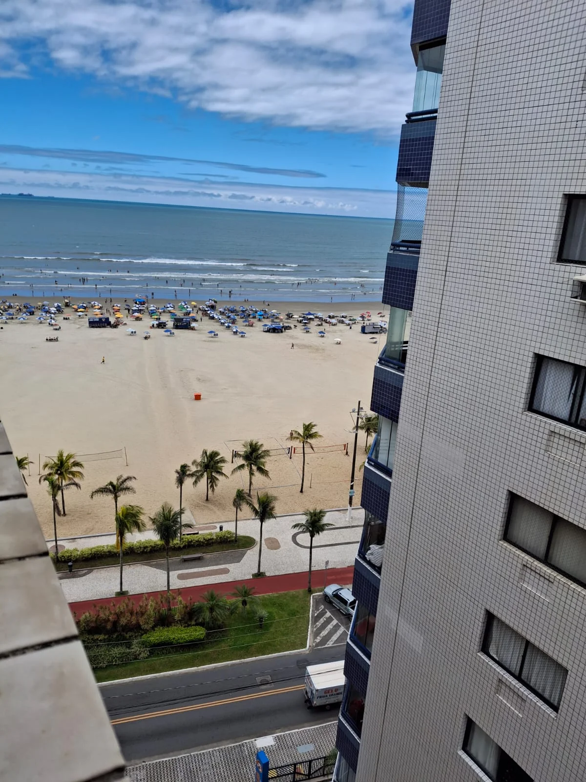 Vista do 11º andar para a Praia da Guilhermina, com orla, coqueiros e o mar